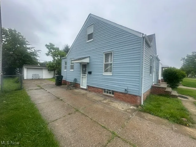 Back of property featuring concrete driveway and a patio
