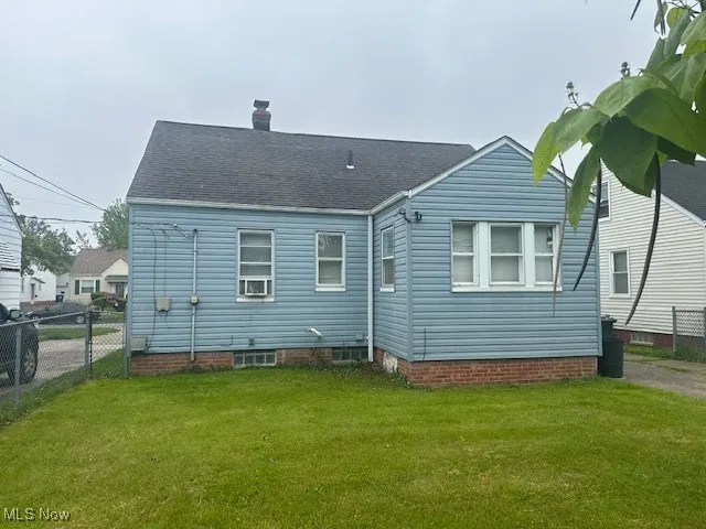 Rear view of house featuring a chimney and roof with shingles