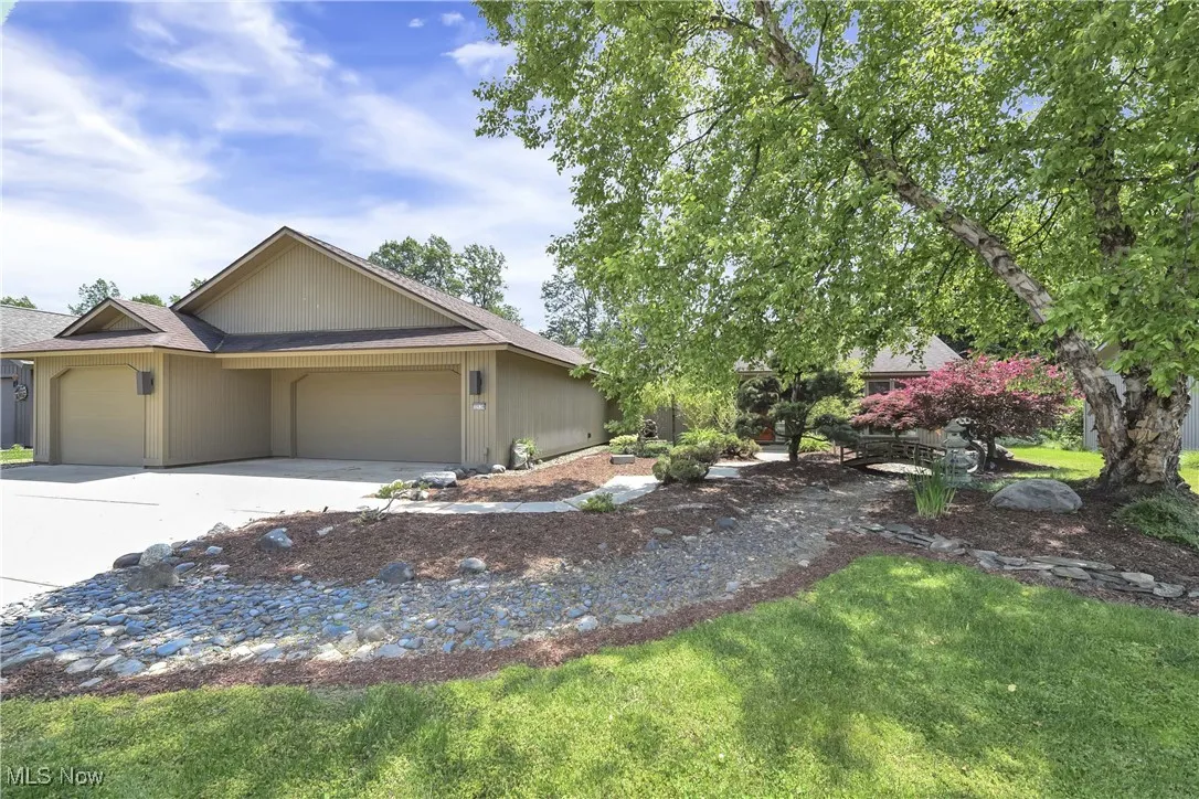 Ranch-style home featuring an attached garage, concrete driveway, and a front yard