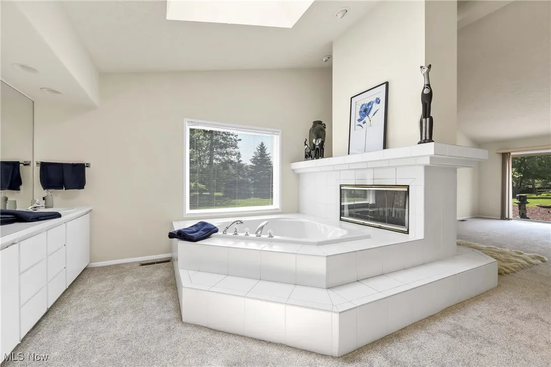 Primary full bathroom with double sided fireplace