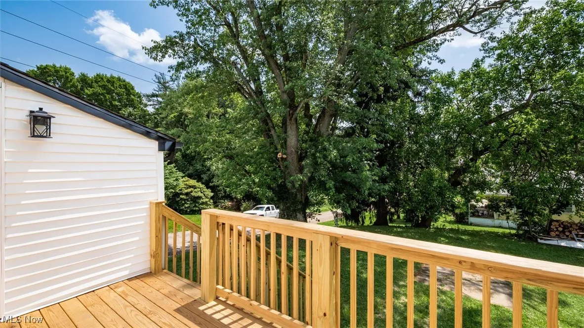 Deck featuring a lawn and view of scattered trees