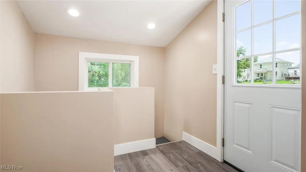 Entryway with wood finished floors and recessed lighting