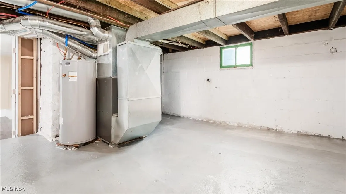 Basement featuring water heater and heating unit