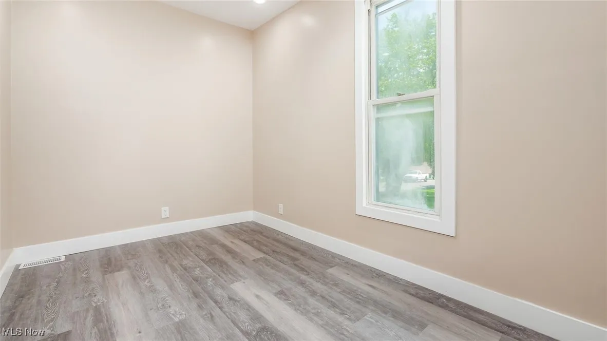 Unfurnished room featuring wood finished floors and baseboards