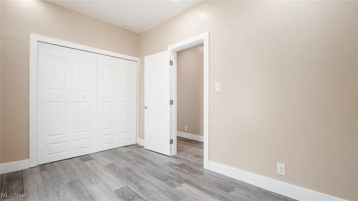 Unfurnished bedroom with wood finished floors and a closet
