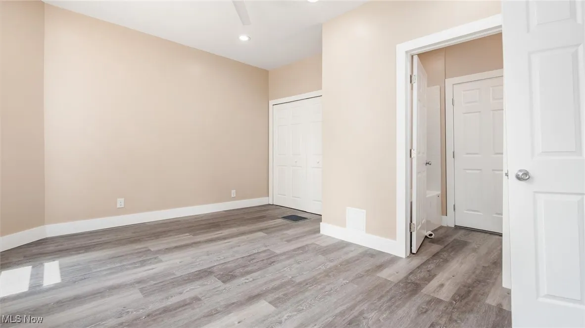 Unfurnished bedroom featuring light wood finished floors, a closet, and recessed lighting