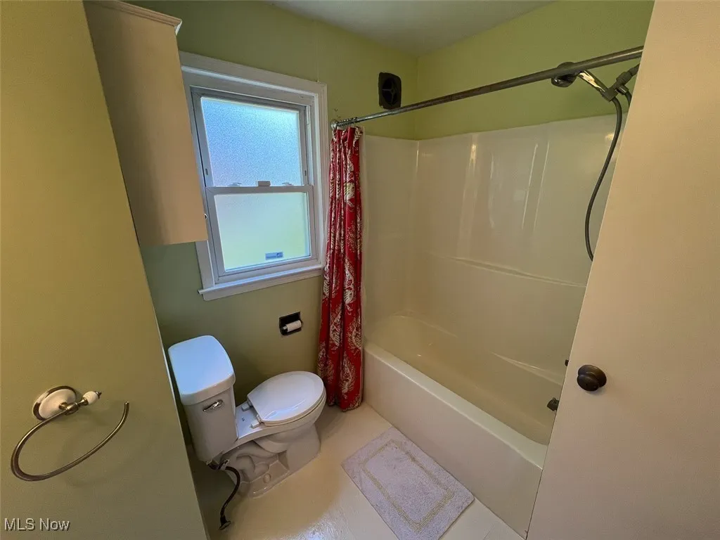 Full bath featuring toilet and shower / tub combo