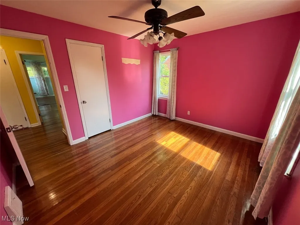 Bedroom with dark wood-type flooring and ceiling fan