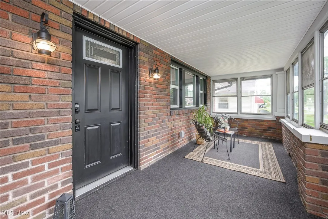 Sunroom / solarium featuring brick wall and carpet flooring