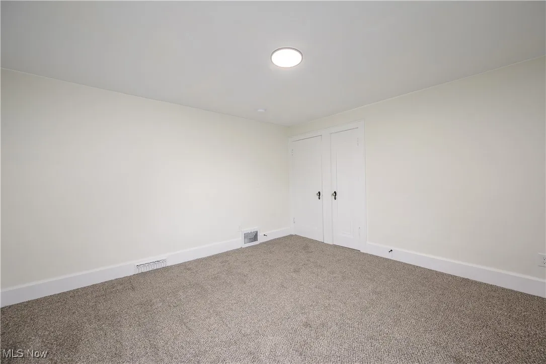 Carpeted empty room featuring baseboards
