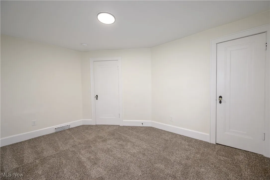 Unfurnished room with carpet floors and baseboards