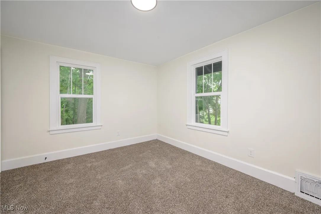 Carpeted empty room with baseboards