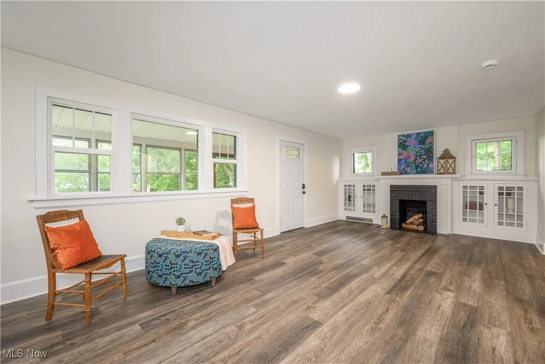 Sitting room with wood finished floors, a fireplace, and recessed lighting