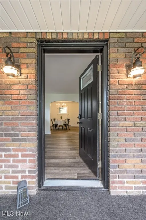 Doorway to property featuring brick siding