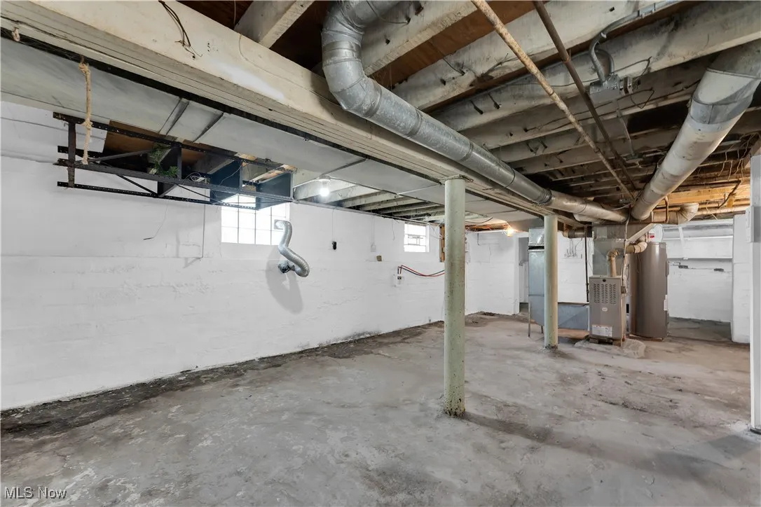 Basement featuring water heater and heating unit