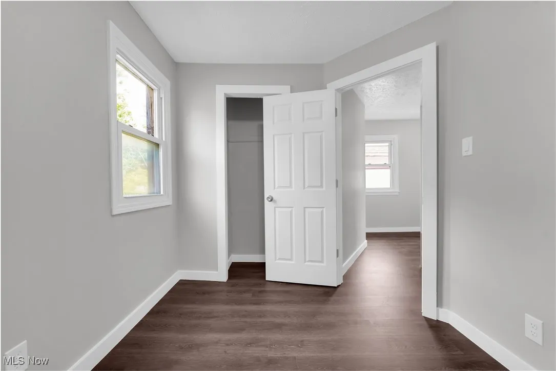 Unfurnished bedroom with dark wood-type flooring and a closet