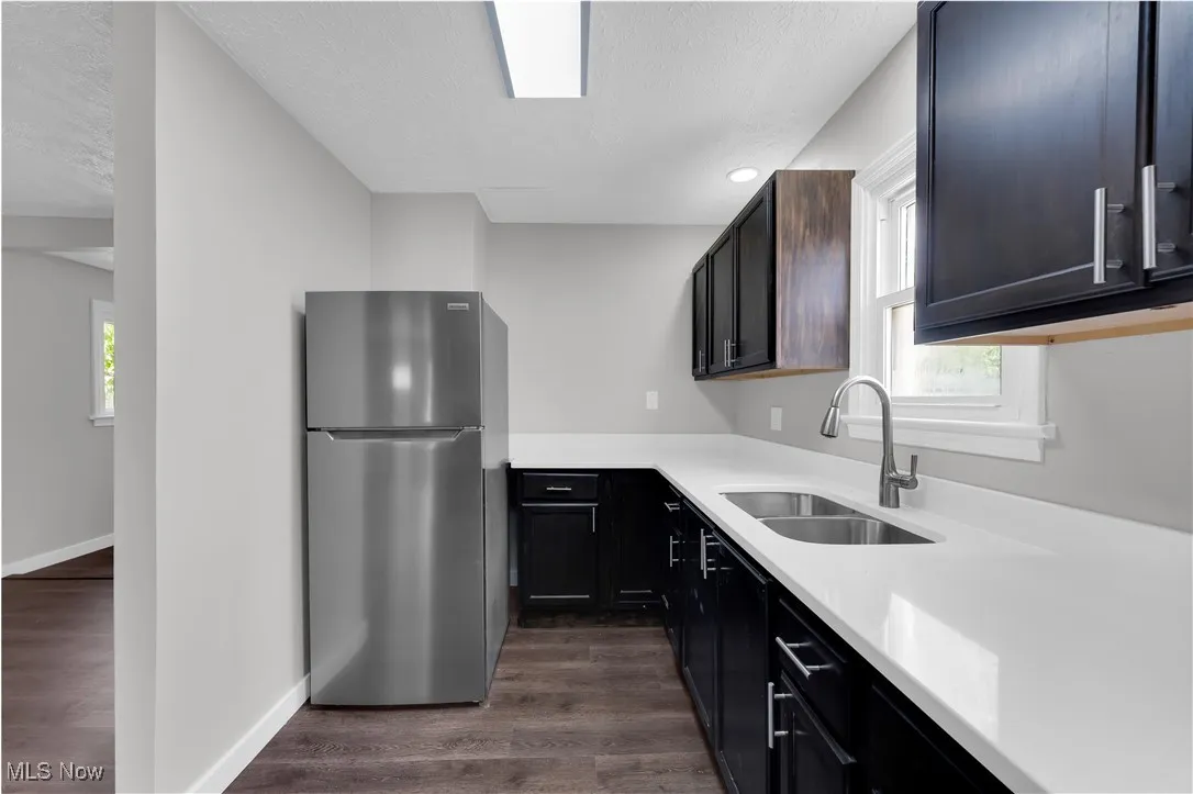 Kitchen with freestanding refrigerator, light countertops, healthy amount of natural light, a textured ceiling, and recessed lighting