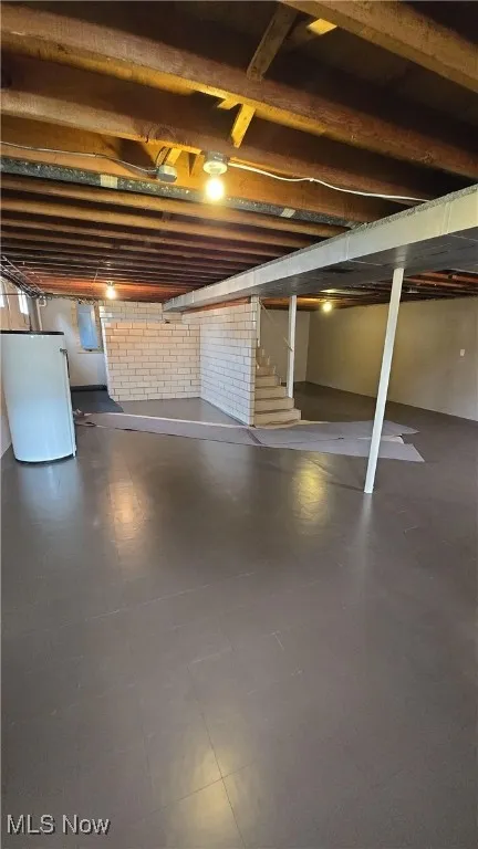 Basement featuring refrigerator and stairs