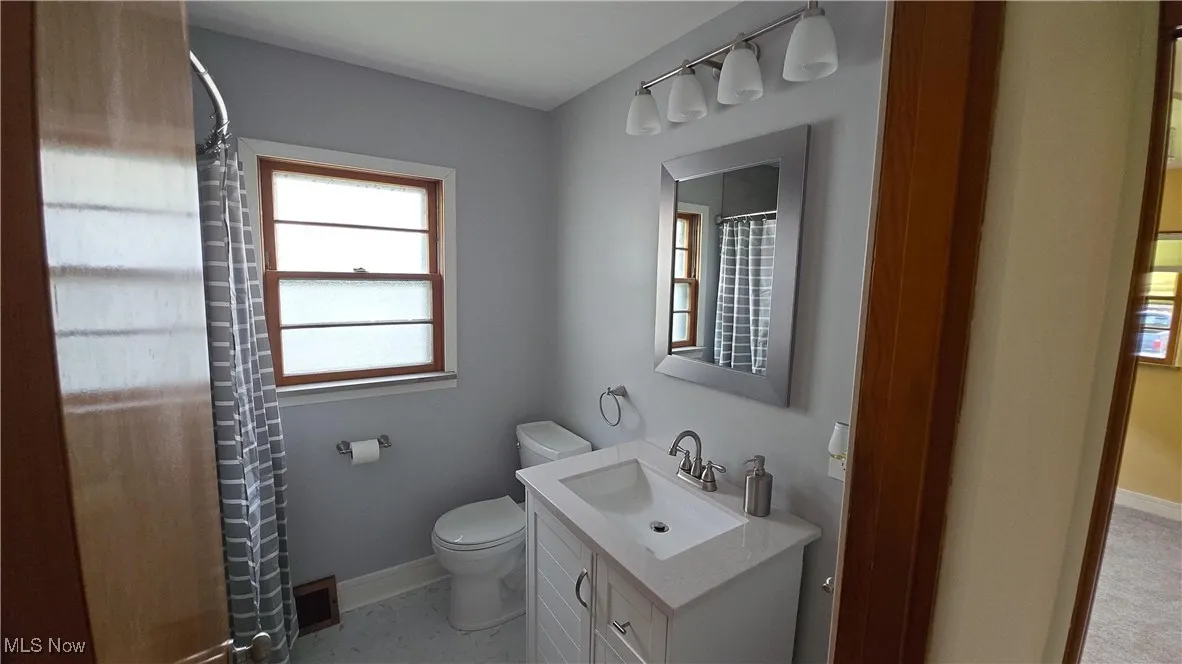 Full bathroom with vanity and curtained shower