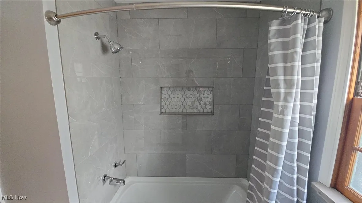 Bathroom with shower / bath combination with curtain