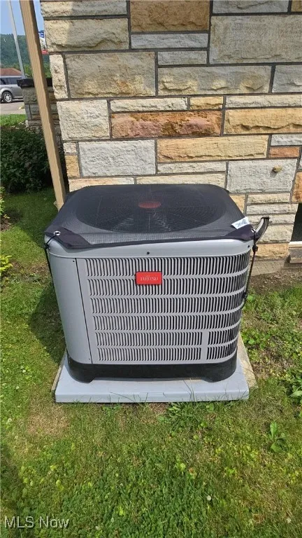Exterior view of a central air condition unit and stone siding