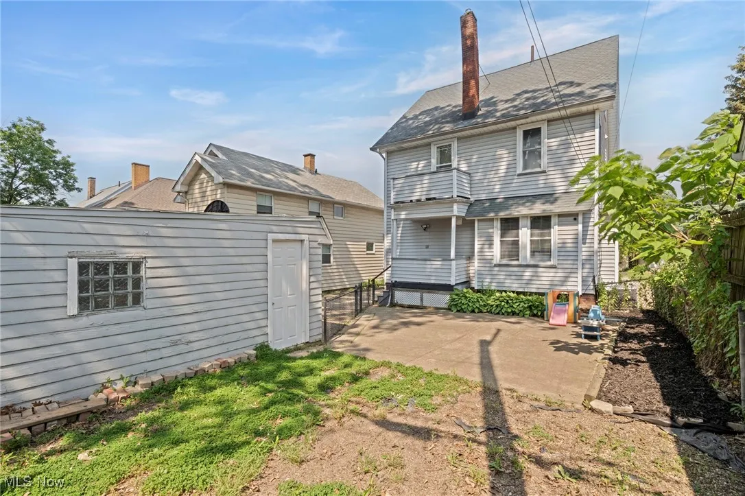 Back of property with a patio area, an outbuilding, and a chimney