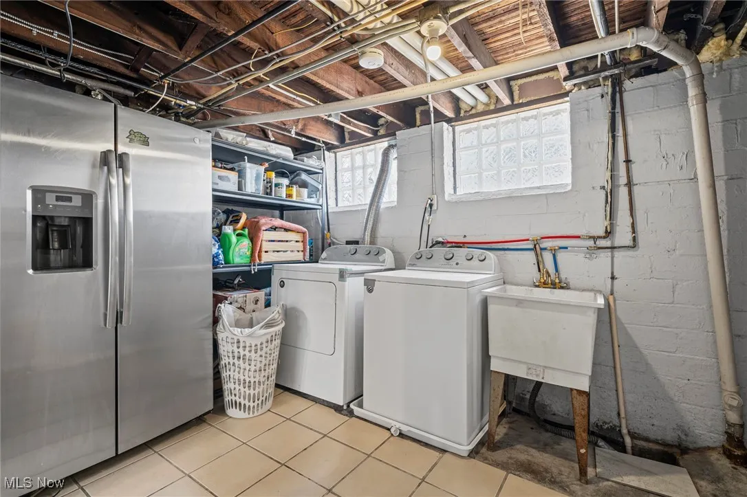 Laundry area featuring washer and clothes dryer and light tile patterned floors