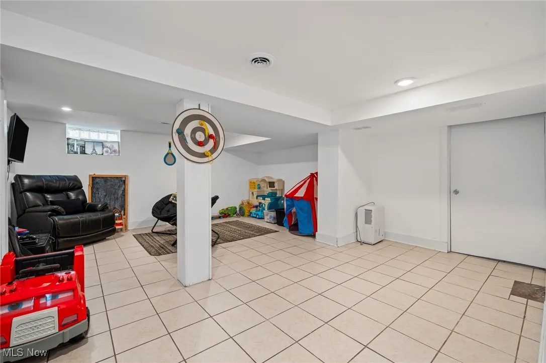 Basement with recessed lighting and light tile patterned flooring