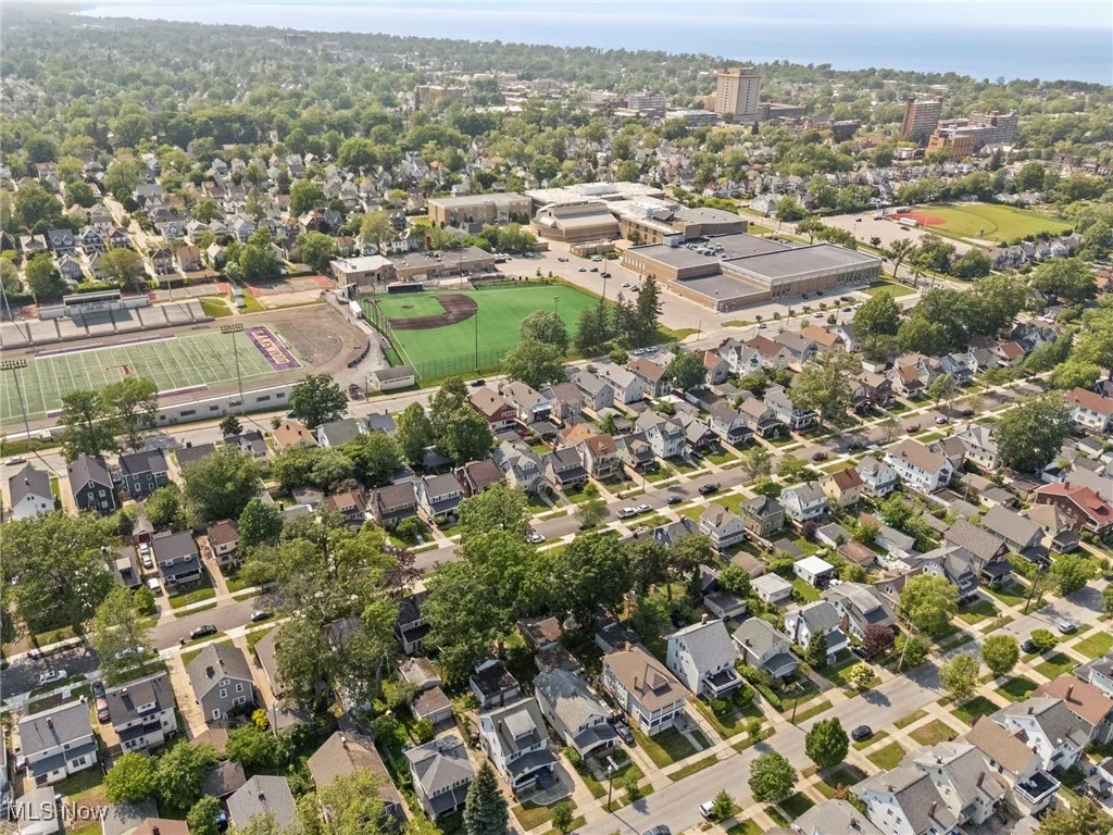 Aerial view of property and surrounding area featuring nearby suburban area