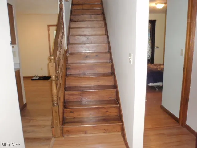 Stairs featuring wood finished floors
