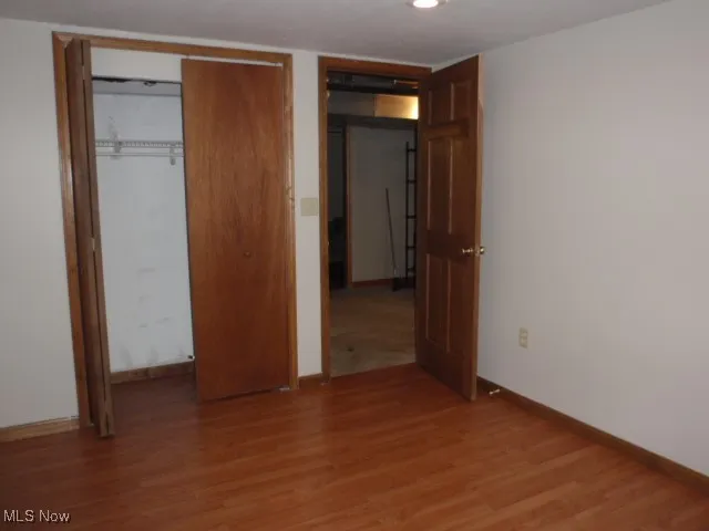 Unfurnished bedroom with light wood-type flooring and a closet