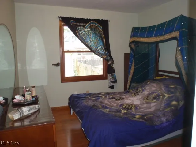 Bedroom with wood finished floors and baseboards
