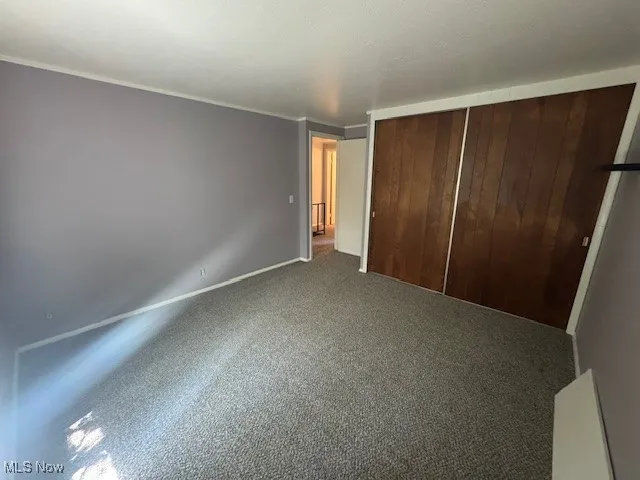 Unfurnished bedroom with carpet floors and a closet