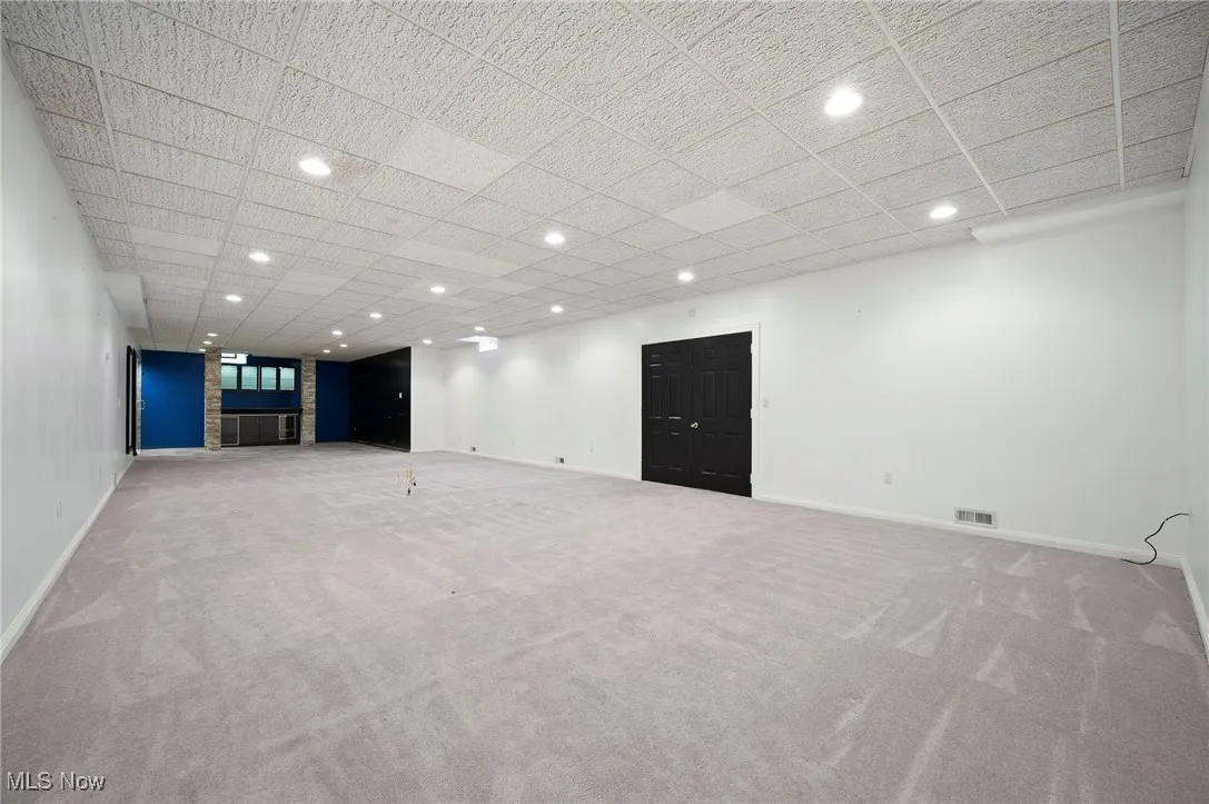 Basement featuring carpet, recessed lighting, a drop ceiling, wet bar and shower