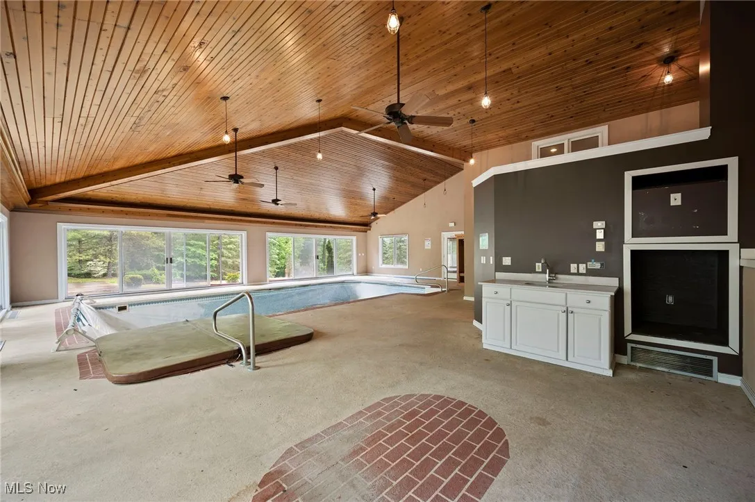 View of swimming pool featuring a ceiling fan and a sink