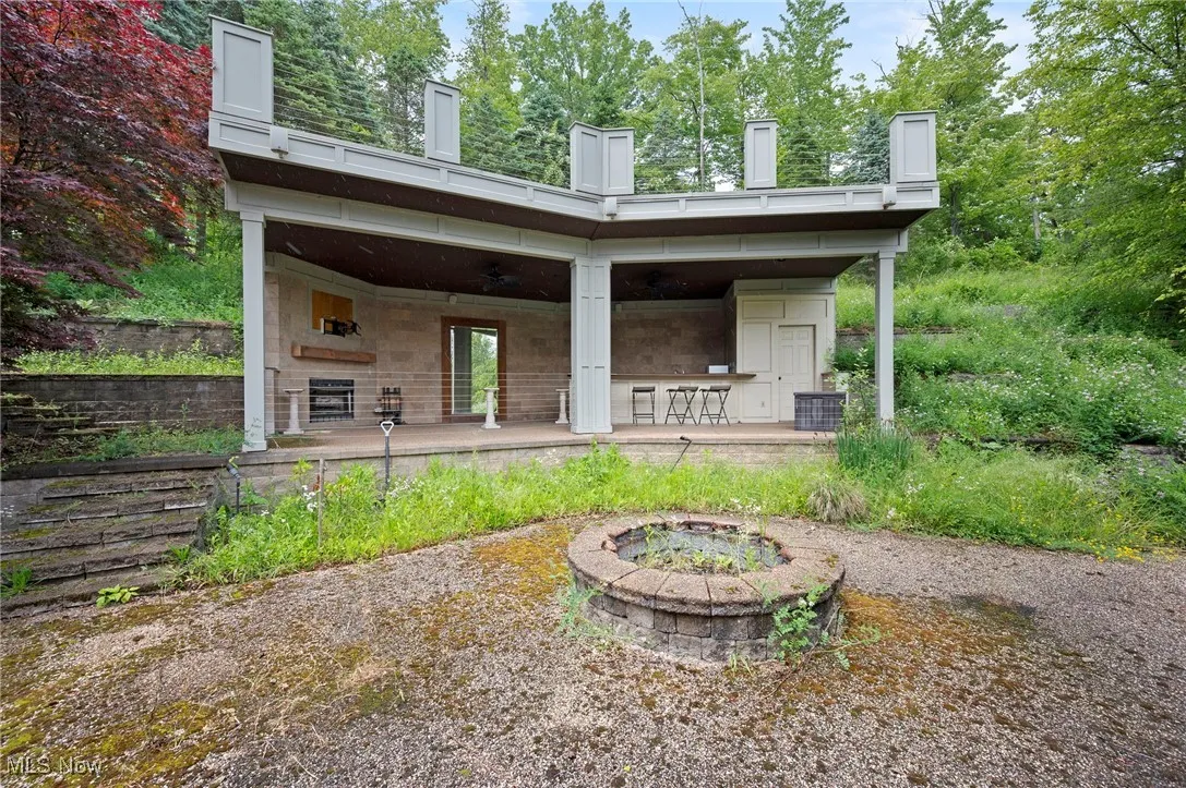 Back of house featuring an outdoor fire pit
