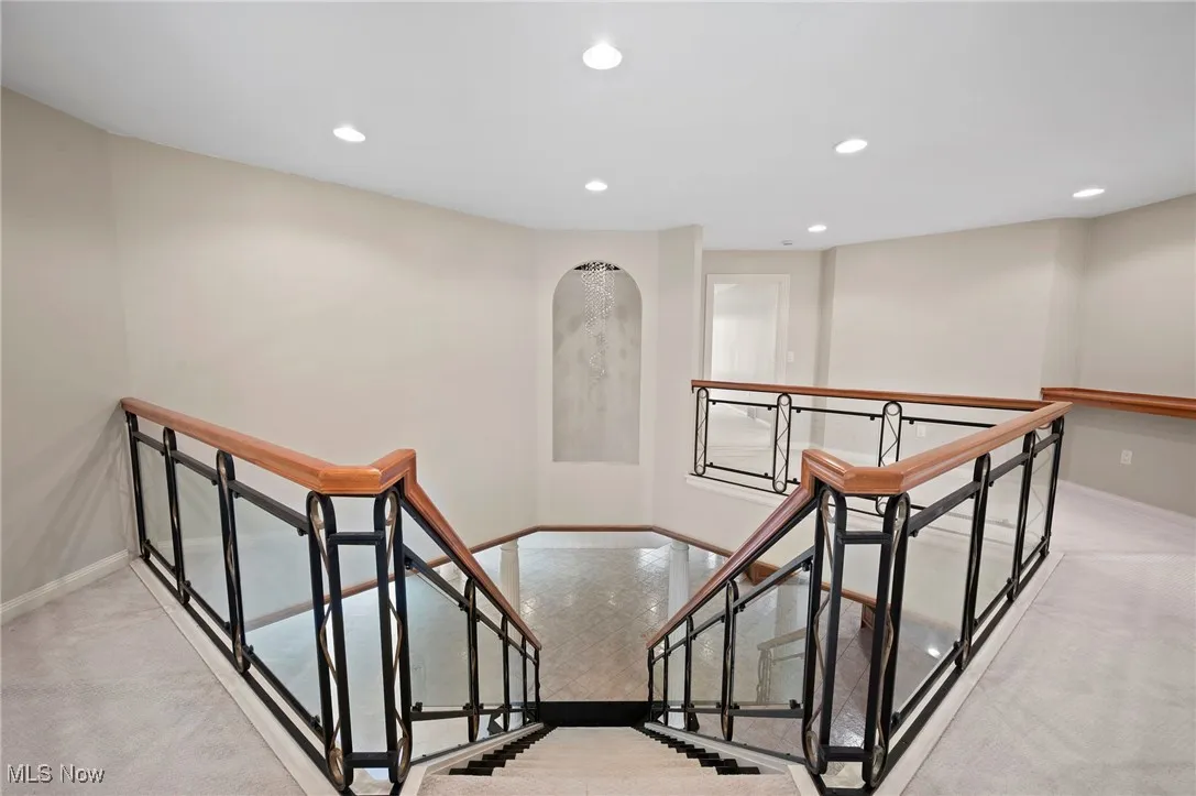 Staircase featuring recessed lighting, carpet flooring, and arched walkways