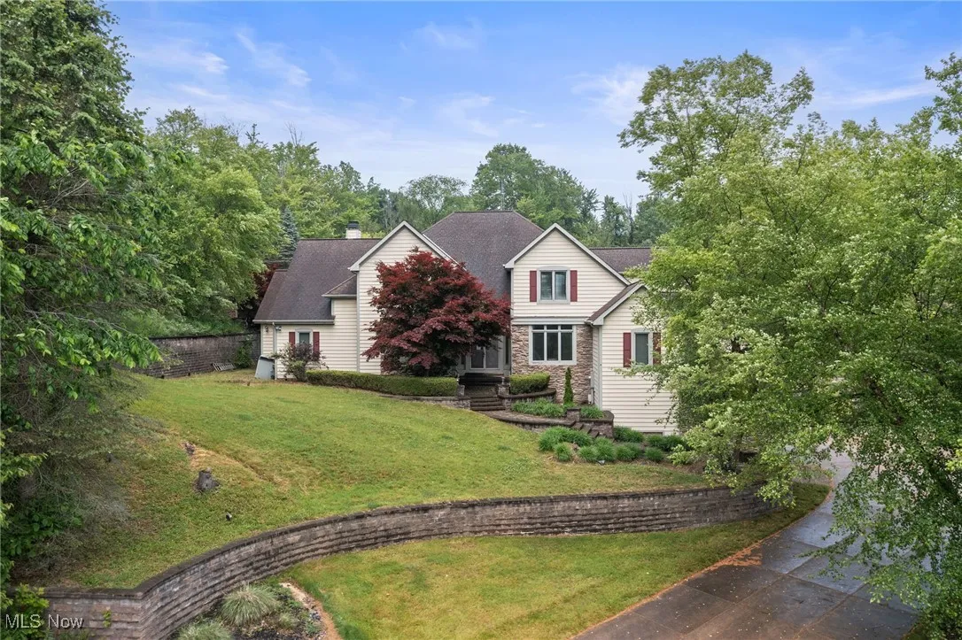 Traditional-style home featuring stone siding and a chimney