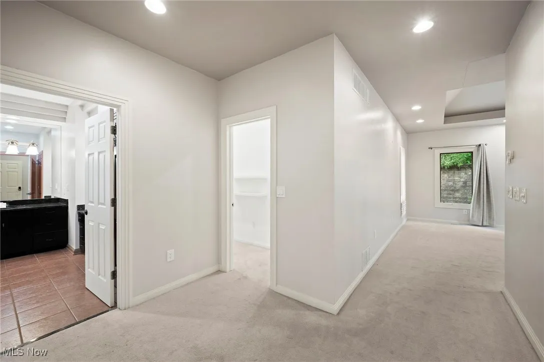 Hall featuring light colored carpet and recessed lighting