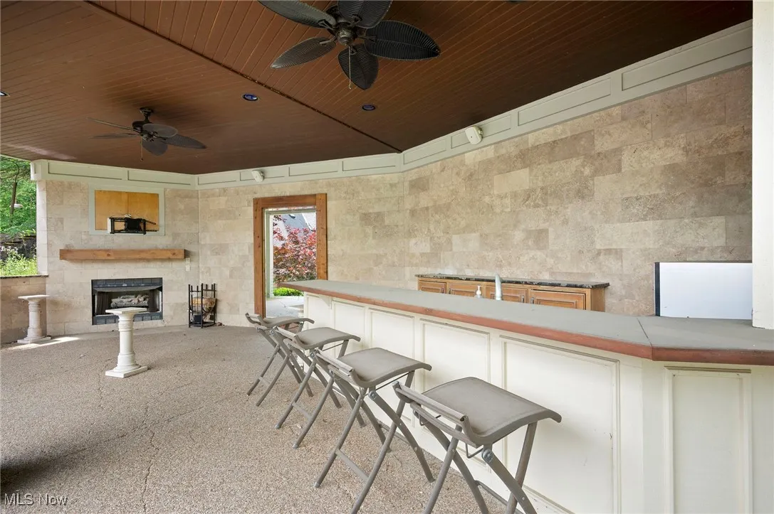 View of patio / terrace with a ceiling fan and fireplace