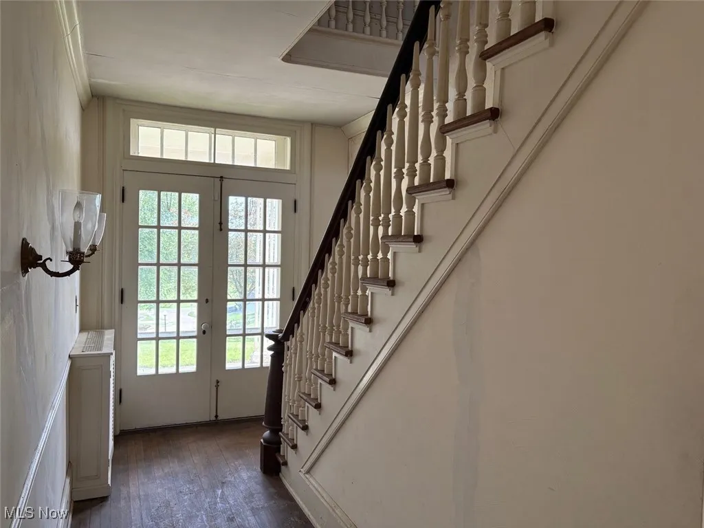 Foyer entrance with stairway and French doors to the covered porch
