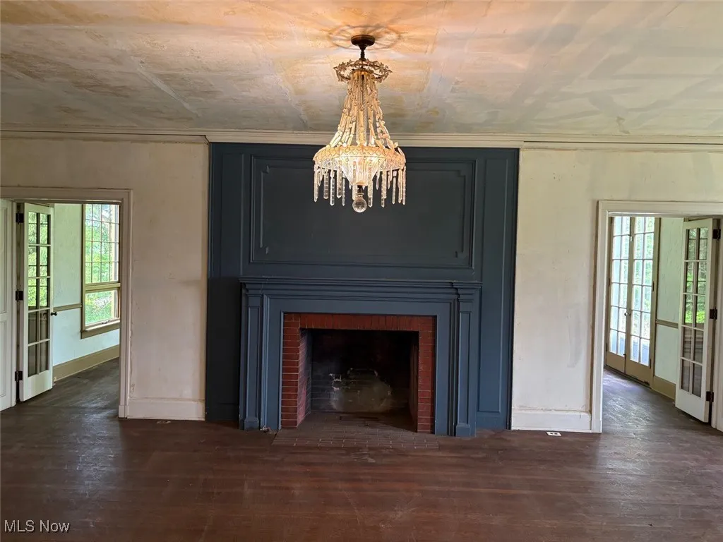 Detailed view of a chandelier, wood finished floors, and a fireplace