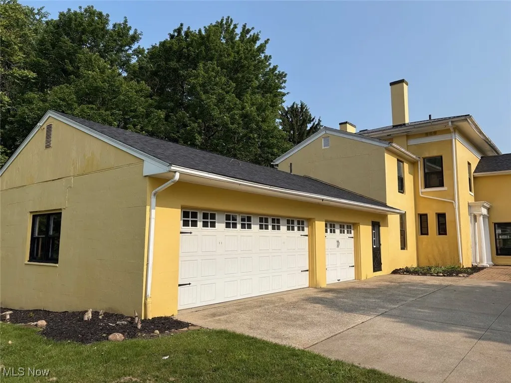 View of side of property featuring an attached 3 car garage.
