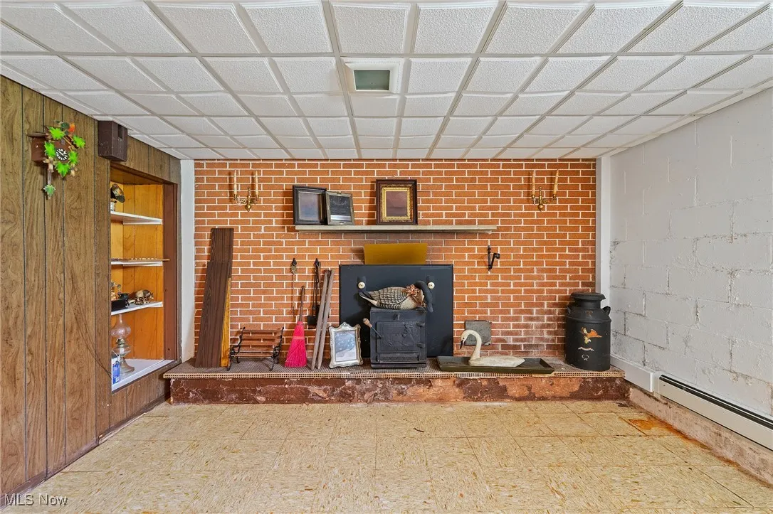 Recreation   room with a wood stove, tile patterned floors.
