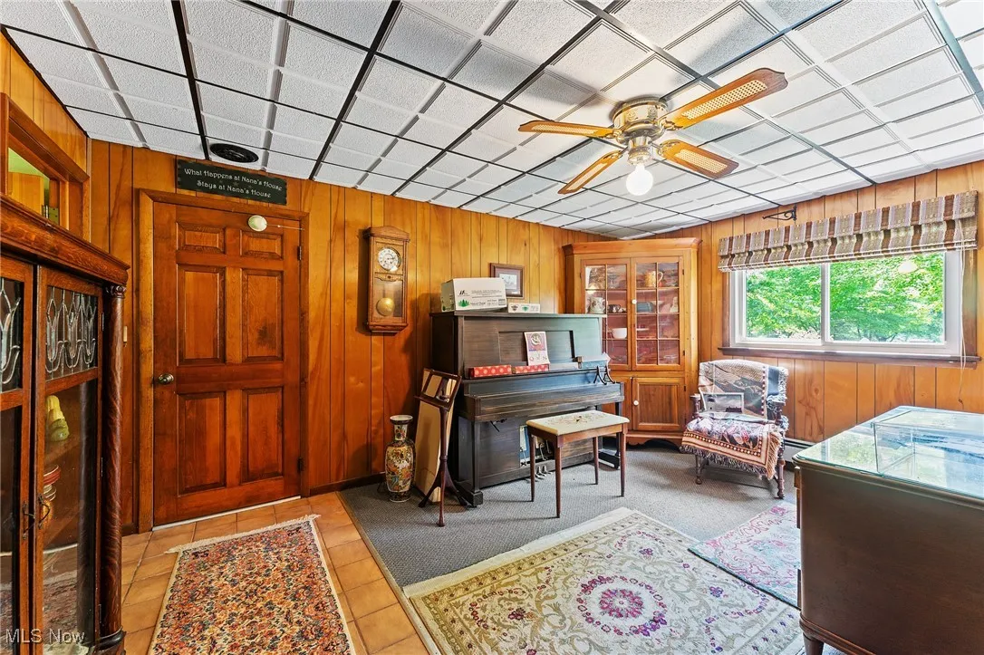First Floor Office with wooden walls and ceiling fan.