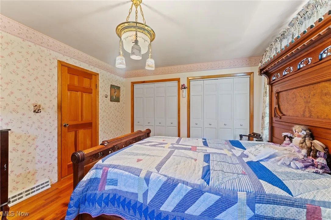 Bedroom featuring hardwood floors, and two closets