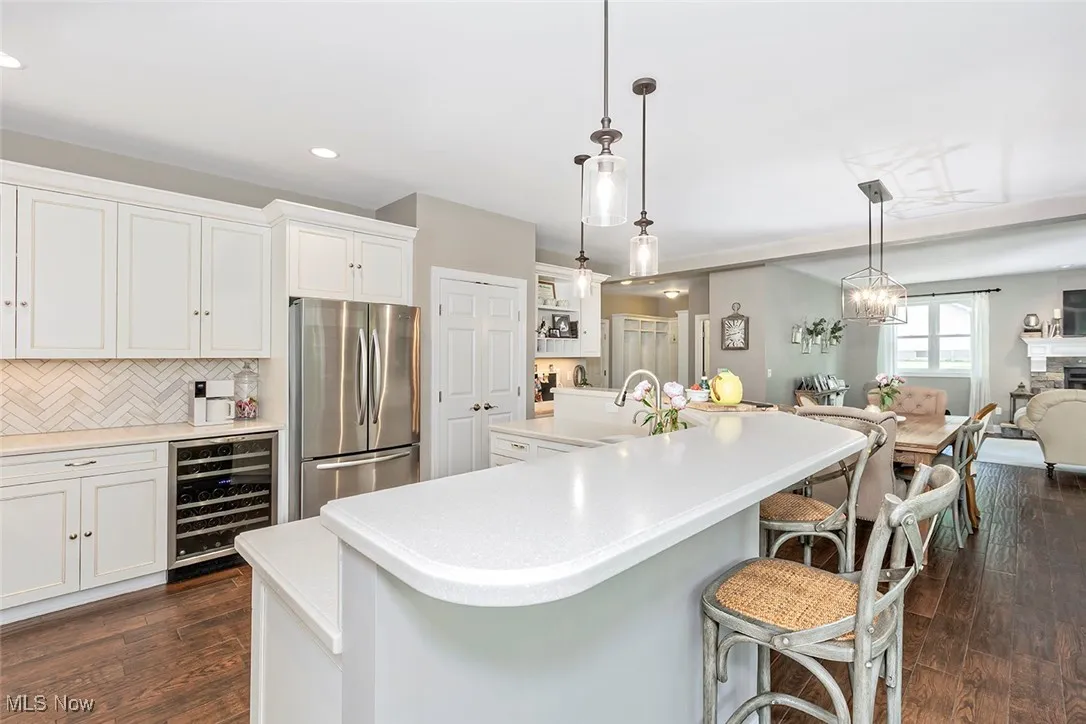 Stainless steel appliance, a beverage refrigerator, marble backsplash.