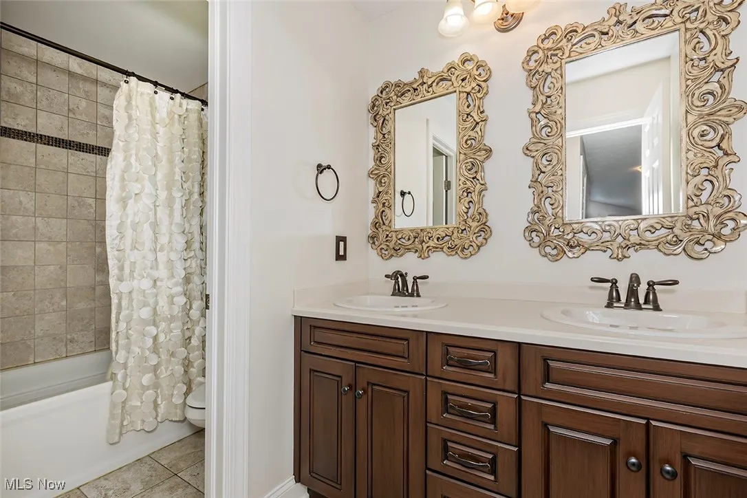 Full common bathroom with dual vanity sinks, wisely seperated from the bathtub shower.