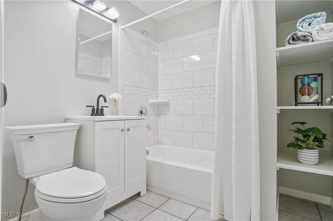 Bathroom featuring tile patterned flooring, shower / bath combo, and vanity