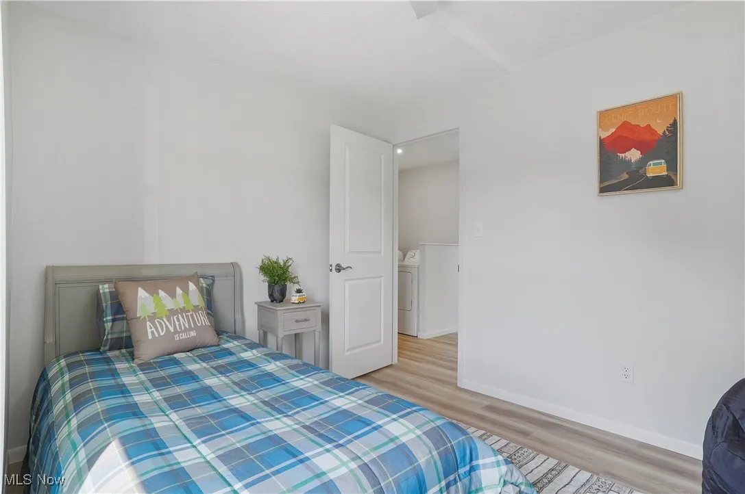 Bedroom with wood finished floors and baseboards